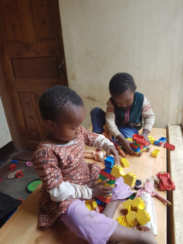 Die zwei Kinder spielen zusammen mit Dublo Blöcken
