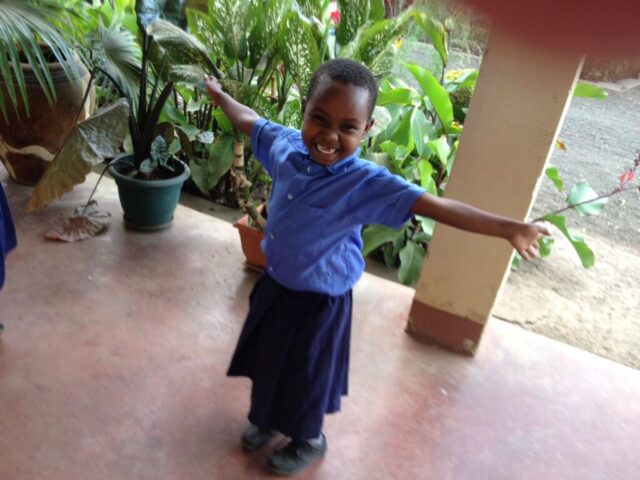 Kind freut sich über die neue Schulkleidung